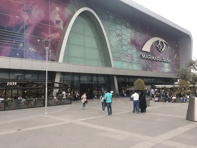 A modern mall exterior showcases a unique architectural design under a cloudy sky.