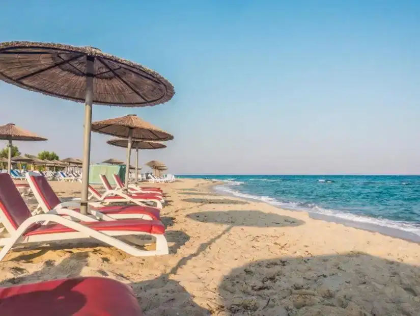 A peaceful beach in Marmaris with umbrellas and sun loungers along the shore.