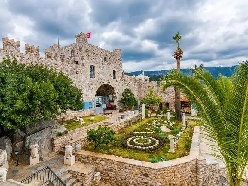 The historical Marmaris Castle overlooking the city, surrounded by lush greenery.