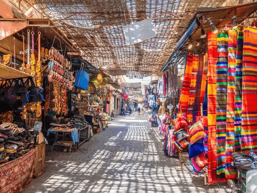 A vibrant and busy Marrakesh market, filled with colorful textiles and handmade crafts.