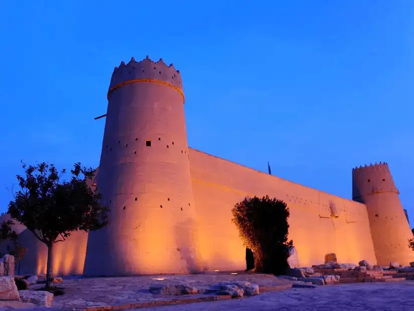 The historic Masmak Castle illuminated at dusk.