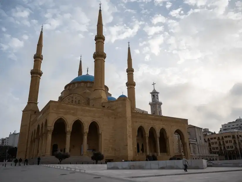 The grand Mohammed Al Amin Mosque in Beirut, with its blue domes and majestic architecture standing against the cloudy sky.