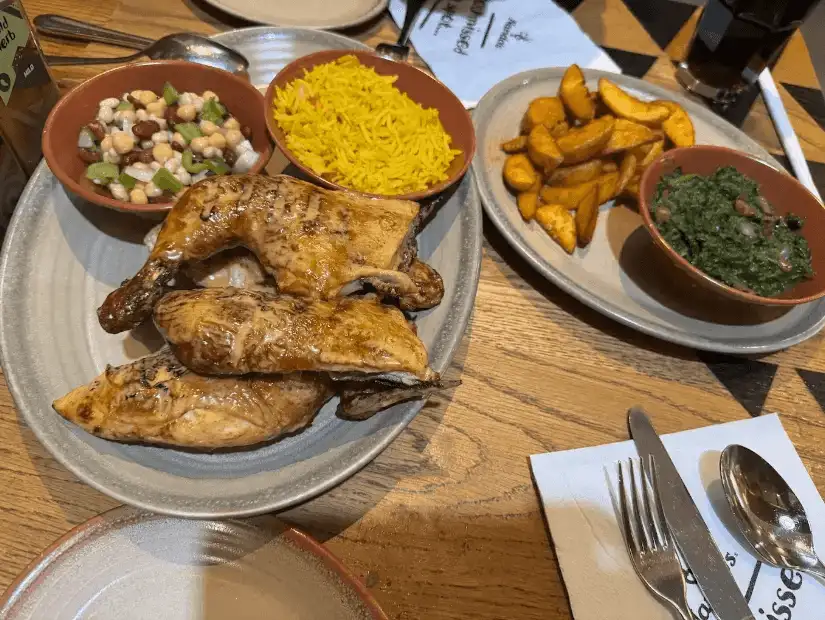 Grilled chicken, rice, and sides from Nando's restaurant.
