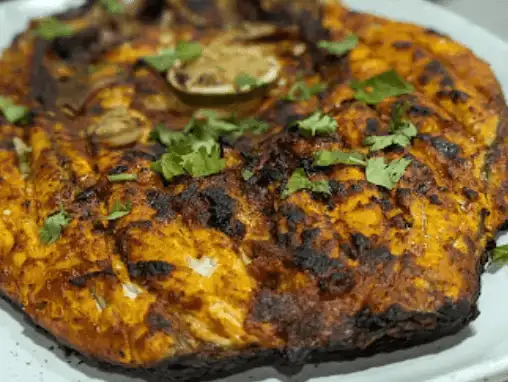 Fish grilled to perfection with a spicy marinade, garnished with fresh cilantro.