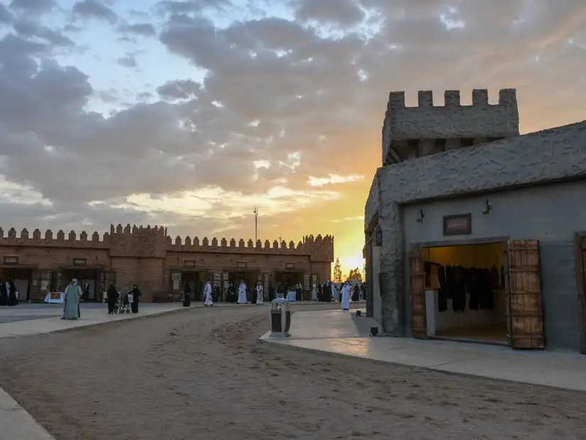 Sunset over a bustling market area with traditional fort-like buildings.