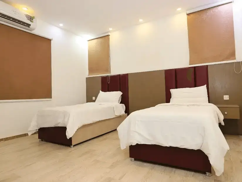 Modern twin bed hotel room with minimalistic decor.