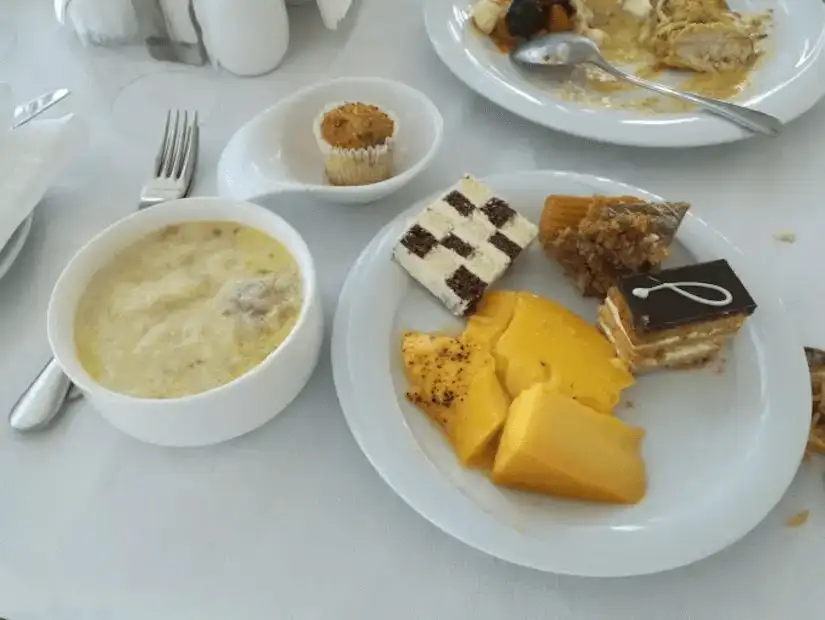 A variety of desserts and a soup bowl on a white tablecloth.