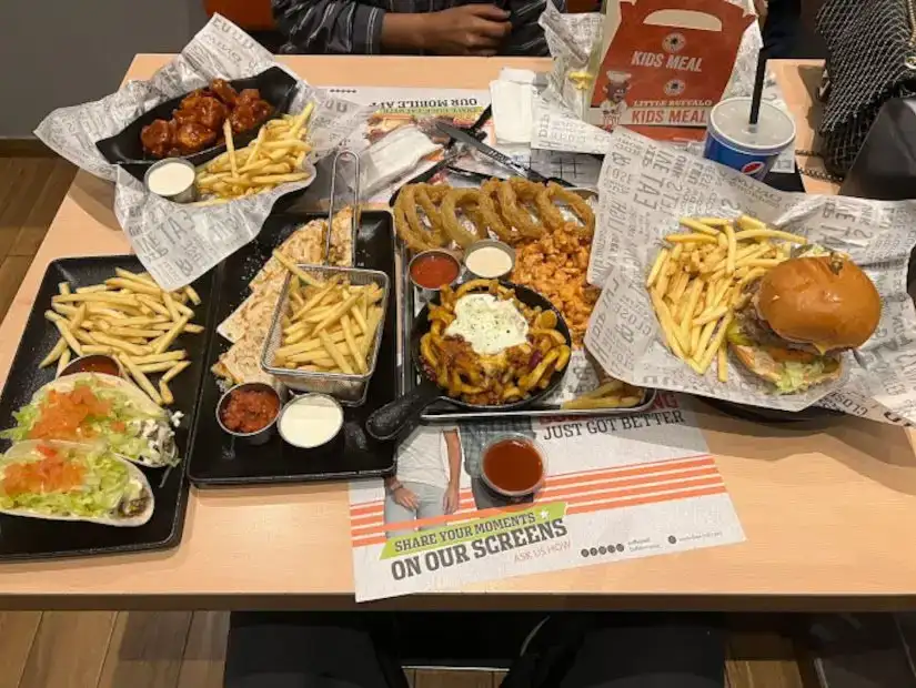 An array of fast food items including fries, burgers, and wings.