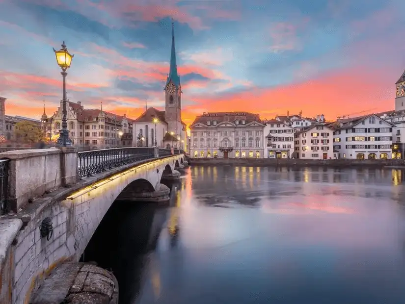 Stunning sunset over Zurich's historic old town and serene river.