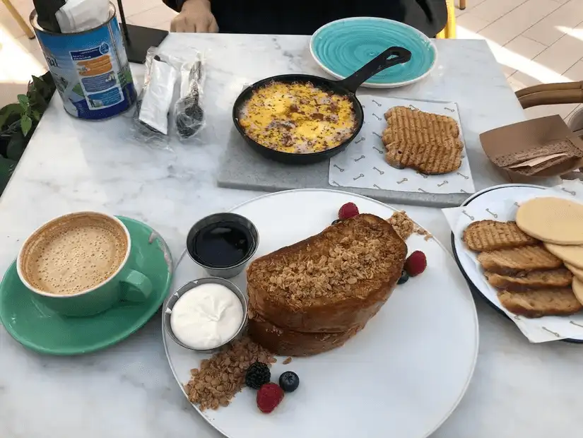 Perfectly toasted brioche topped with a fried egg, cheese, and a side of crisp wedges.