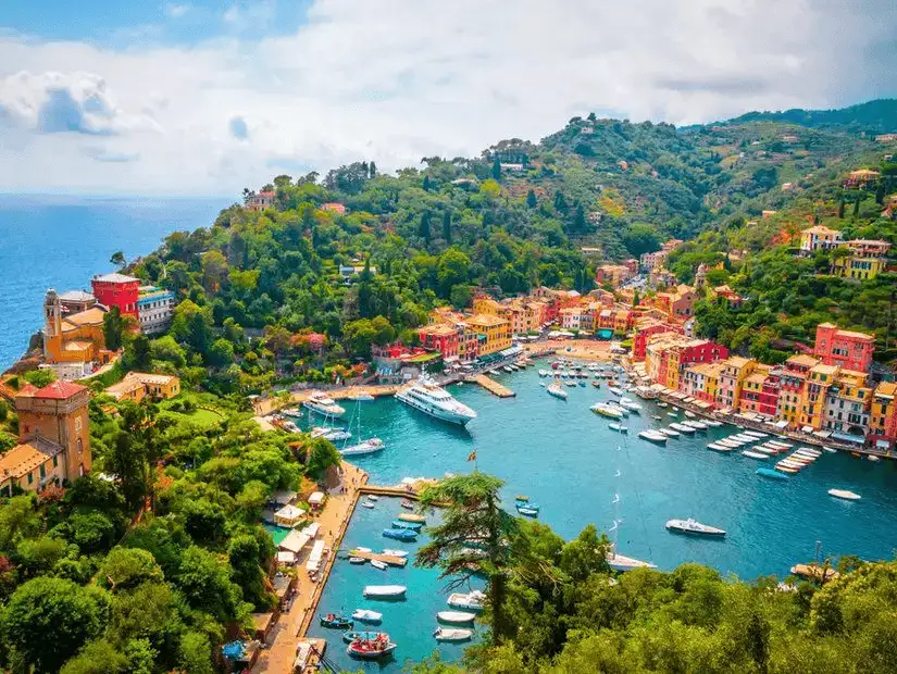 An aerial view of Portofino, revealing the scenic harbor and bustling seaside square, a jewel of the Italian Riviera.