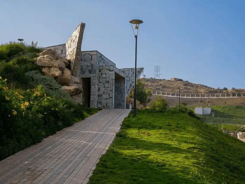 Walkway leading to a stone structure in Prince Hossam Park.