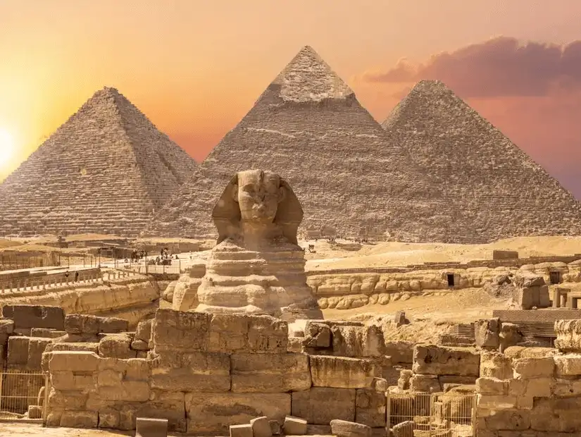 The iconic Sphinx with the Pyramids of Giza in the background, captured during a beautiful sunset.