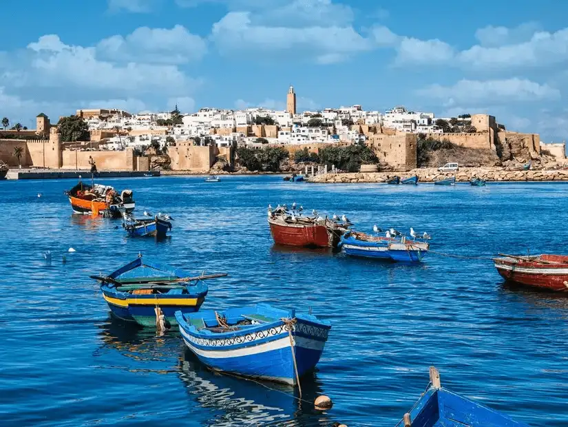 Traditional fishing boats with the historic city of Rabat in the background.