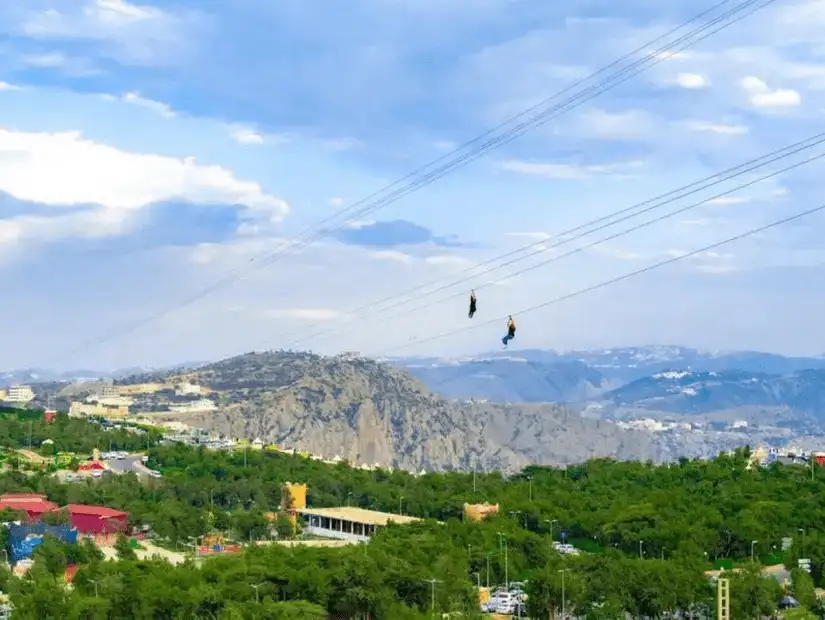 Adventurers zip-lining over the scenic Raghadan Forest.