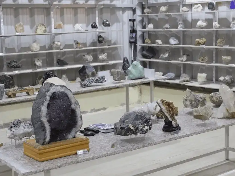Shelves and tabletops overflow with glittering geodes, crystals, and mineral specimens in a compact gem gallery.