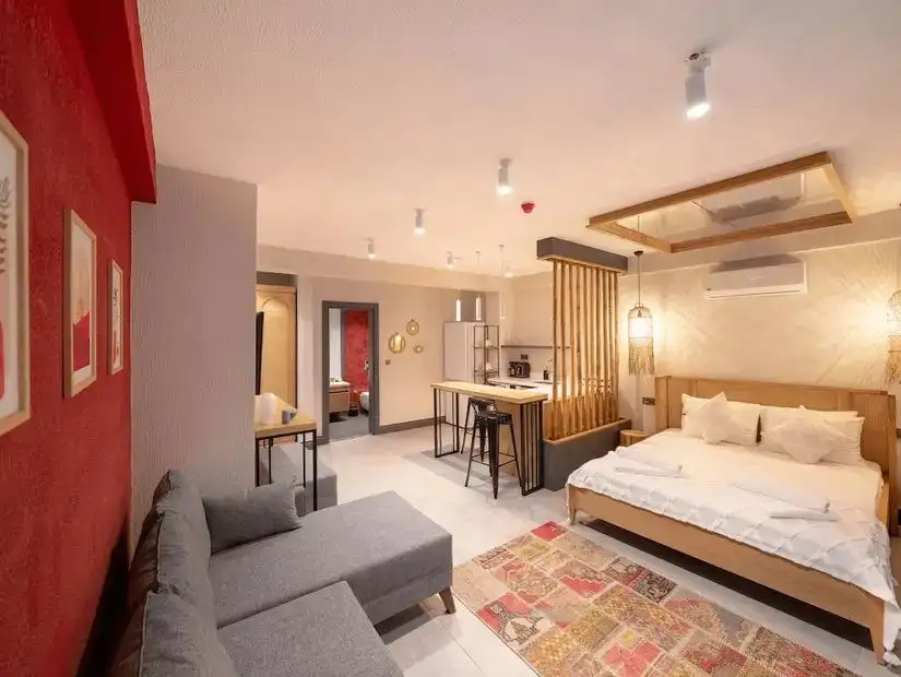A modern and cozy cave hotel room with minimalist design, featuring a wooden bed frame, stylish lamps, and a contemporary decor.
