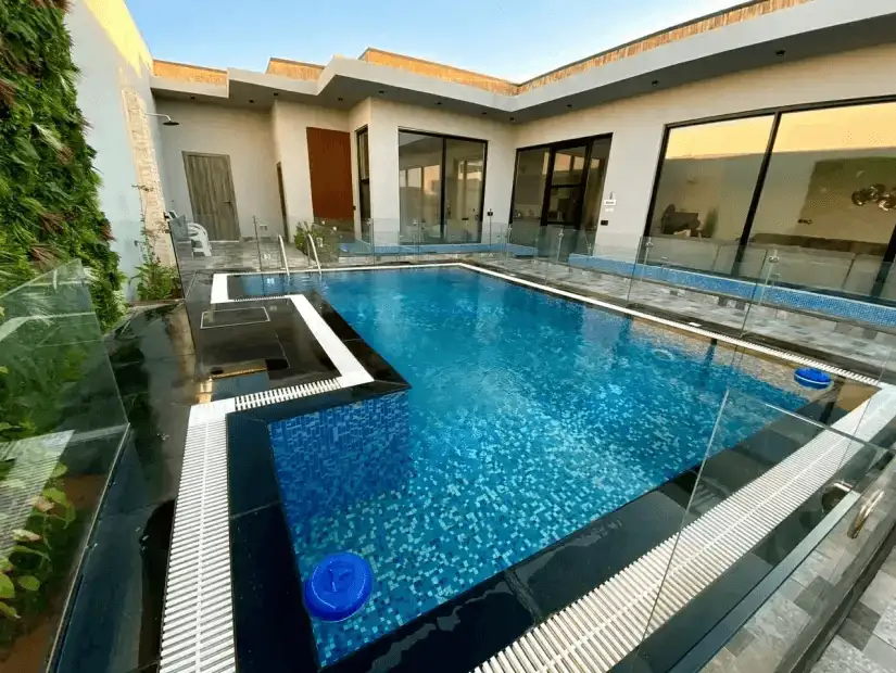 A chic, contemporary chalet with a private pool, surrounded by stylish outdoor furniture and lush landscaping.