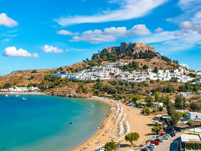 The iconic Lindos Acropolis overlooking a pristine sandy bay.