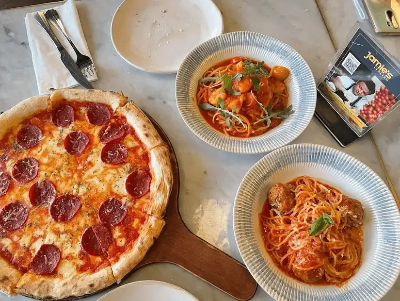 Pepperoni pizza with two varieties of pasta dishes.