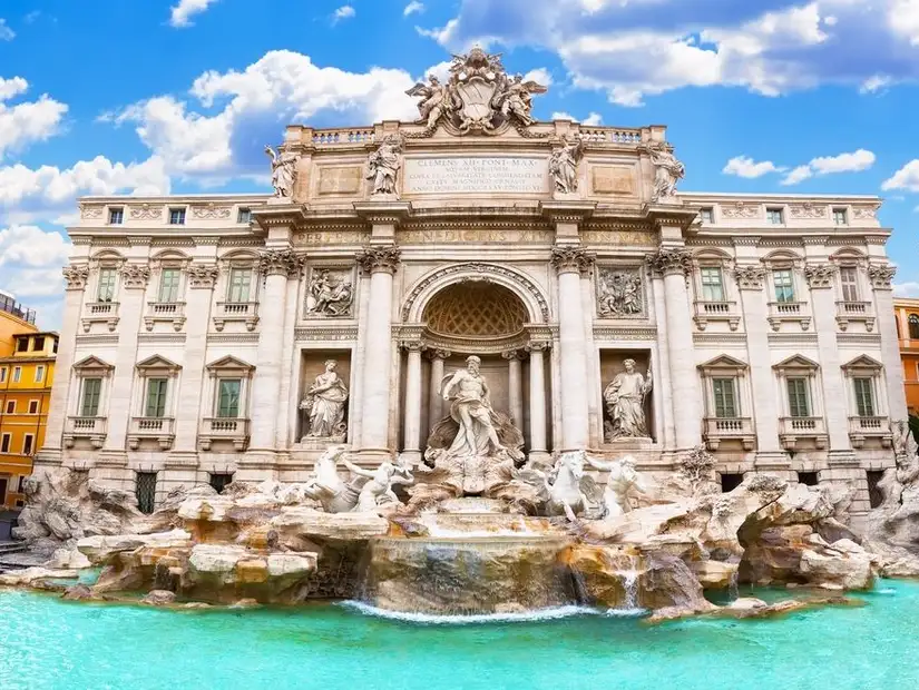 Trevi Fountain in Rome with stunning baroque architecture and clear blue skies.