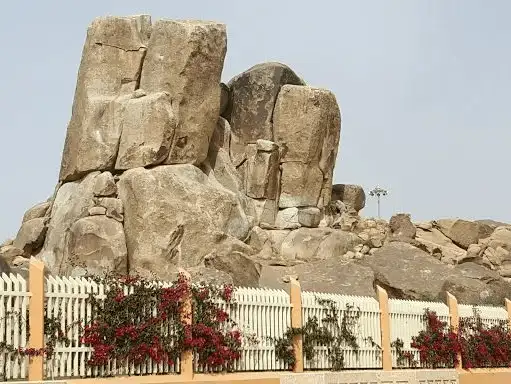 Large rock formations surrounded by flowering plants in a park.