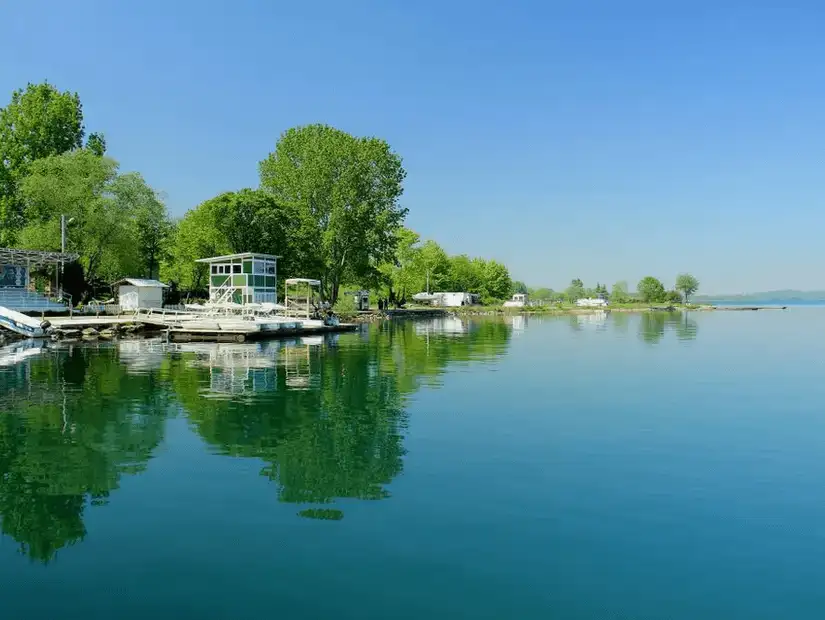 The calm and clear waters of Sapanca Lake reflecting the greenery along its shores.