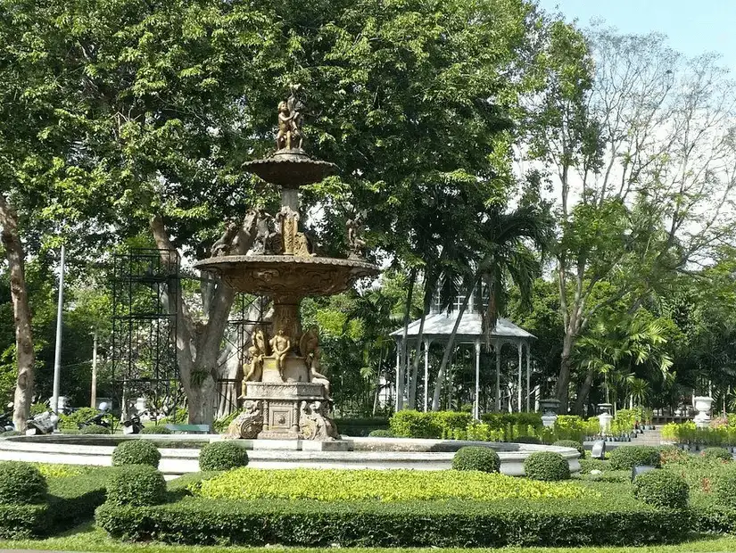 A tranquil fountain surrounded by lush greenery in Saranrom Park.