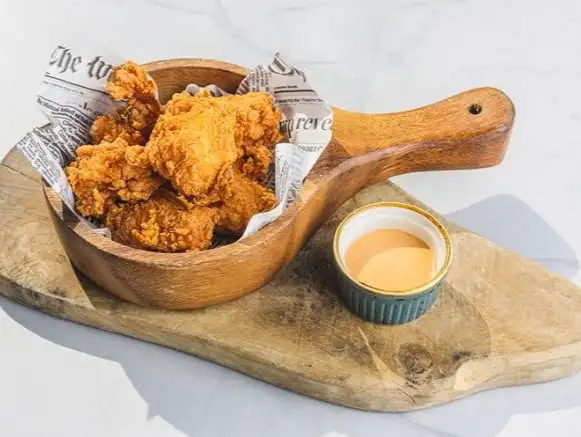 Crispy fried chicken served with a creamy dipping sauce, perfect for a savory treat.