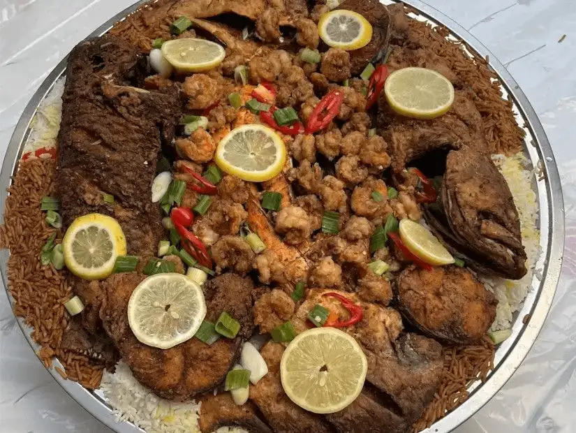 A seafood platter with fried shrimp, fish, and lemon garnish.