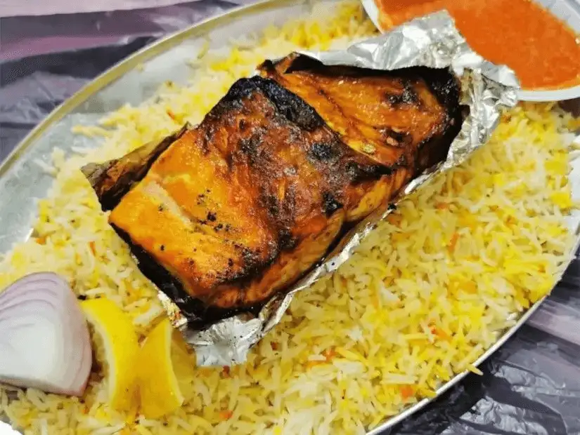 Charred fish fillet wrapped in foil, served with saffron rice.