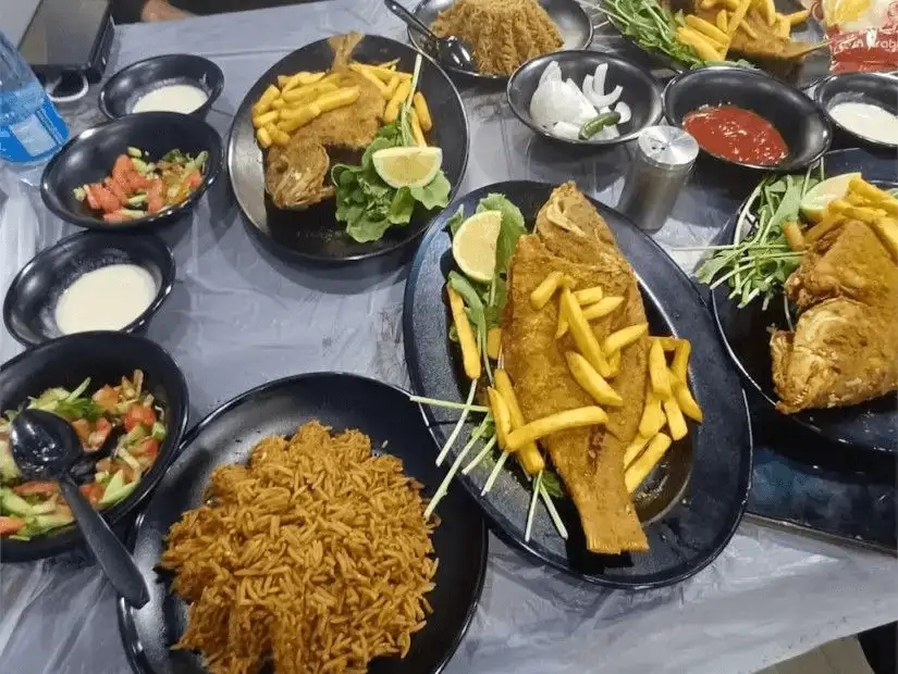 Fried fish with sides of golden fries and spicy rice.