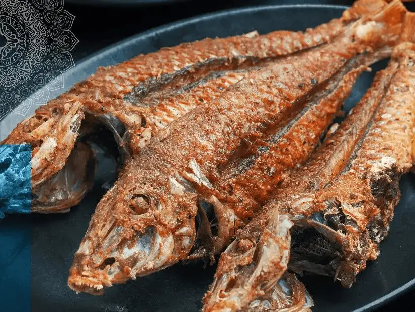 Whole grilled fish with a golden crispy exterior.