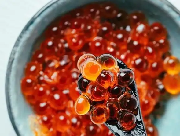 Close-up of glossy salmon roe, a popular delicacy with a burst of ocean flavor.