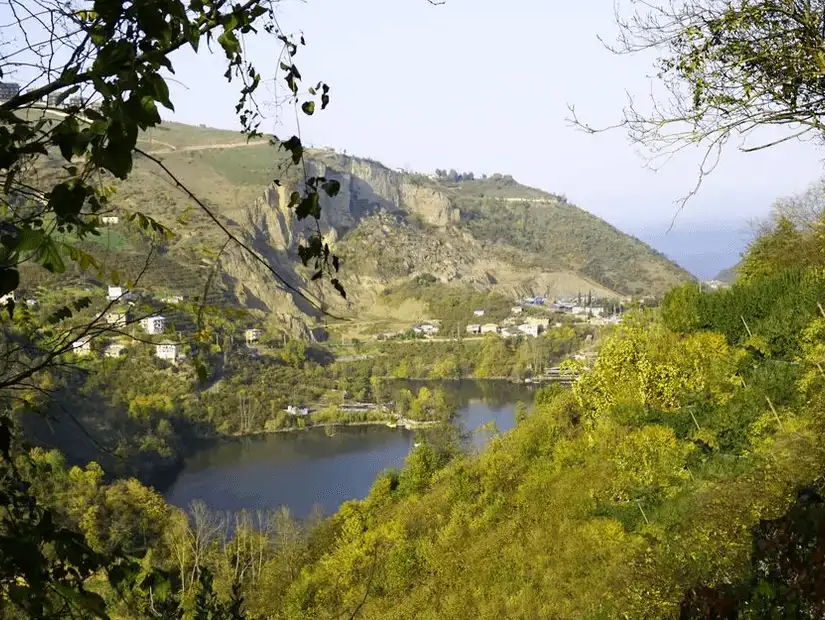 The peaceful Sera Lake surrounded by lush hills and small villages.