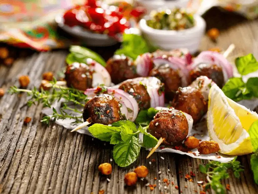 Juicy meatballs on skewers, served with fresh mint and a slice of lemon.