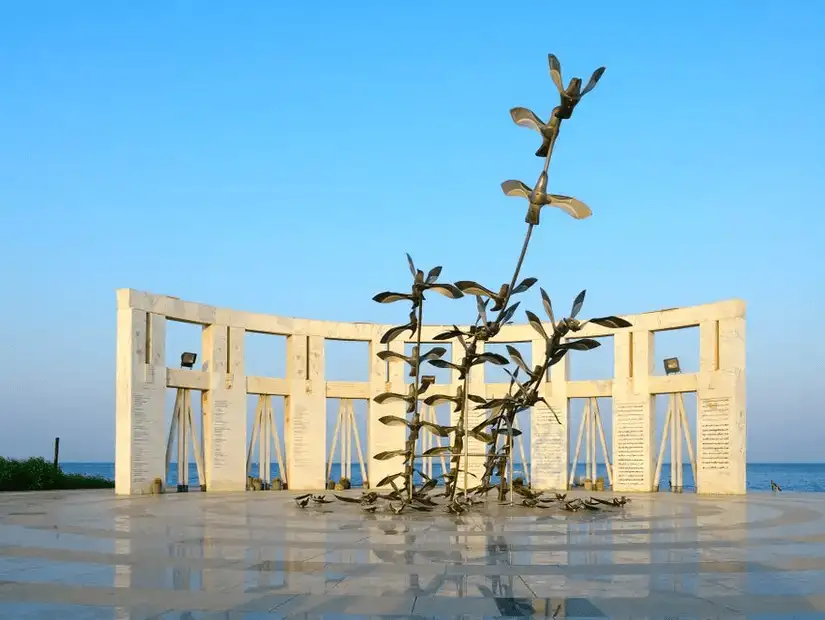 A striking monument surrounded by pillars, featuring a sculptural centerpiece, symbolizing peace and history.