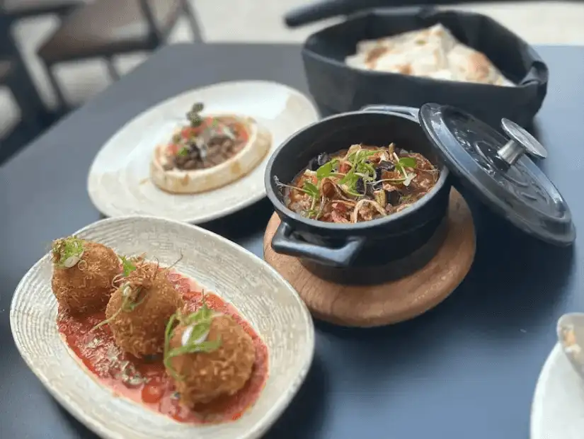 An exquisite Arabic dish from Sharq, featuring a combination of grilled meats with flavorful sauces, accompanied by traditional sides.