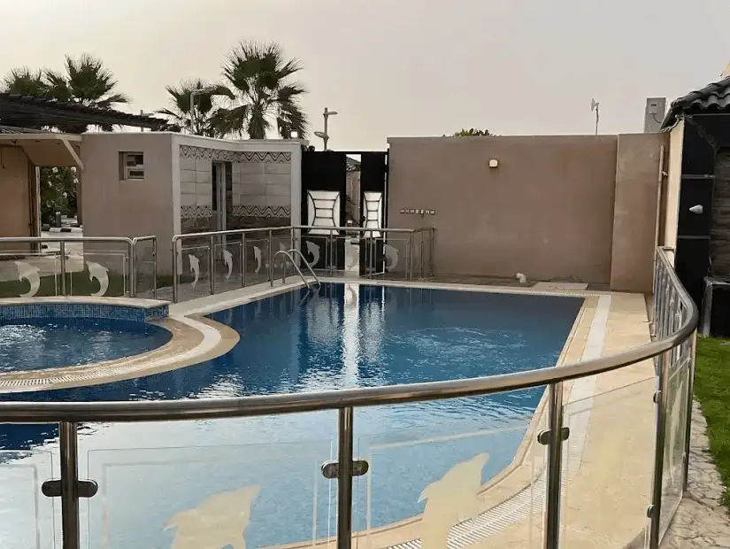 A beautifully designed chalet with a modern pool area, surrounded by vibrant landscaping and cozy lounge spots.