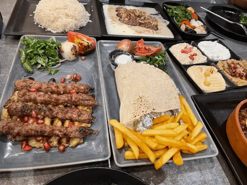 A traditional dish with perfectly grilled meat, served alongside rice, vegetables, and refreshing sides.