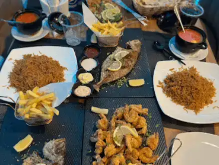 Diverse seafood dining experience with dishes ranging from fries to seasoned rice.