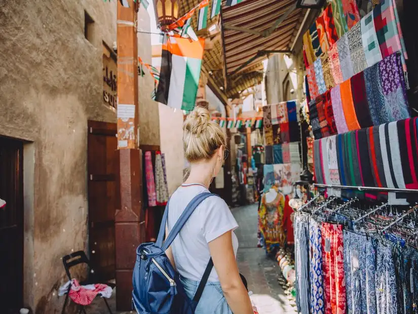 Visitor exploring a market filled with vibrant textiles and traditional crafts.