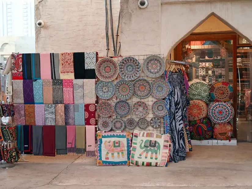 Colorful textiles and handcrafted decor displayed at a traditional souk stall.