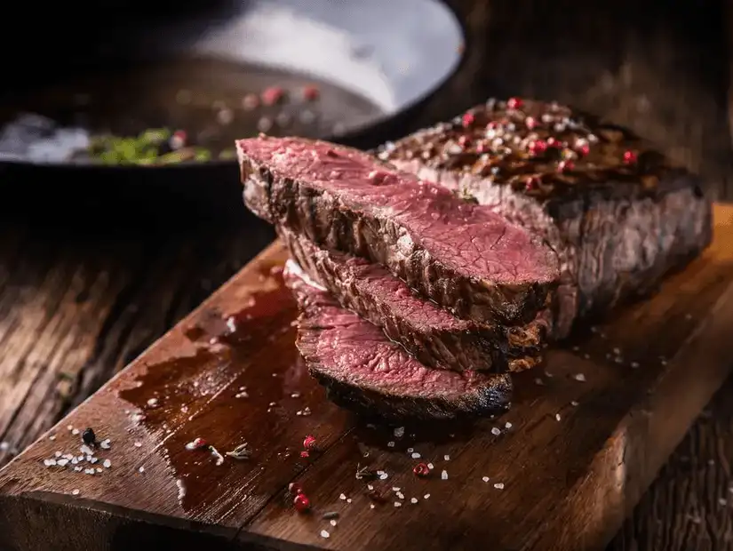 A high-end presentation of perfectly cooked steak, sliced and seasoned with herbs and spices.