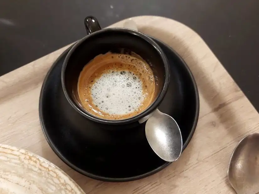 Freshly brewed espresso in a black cup.