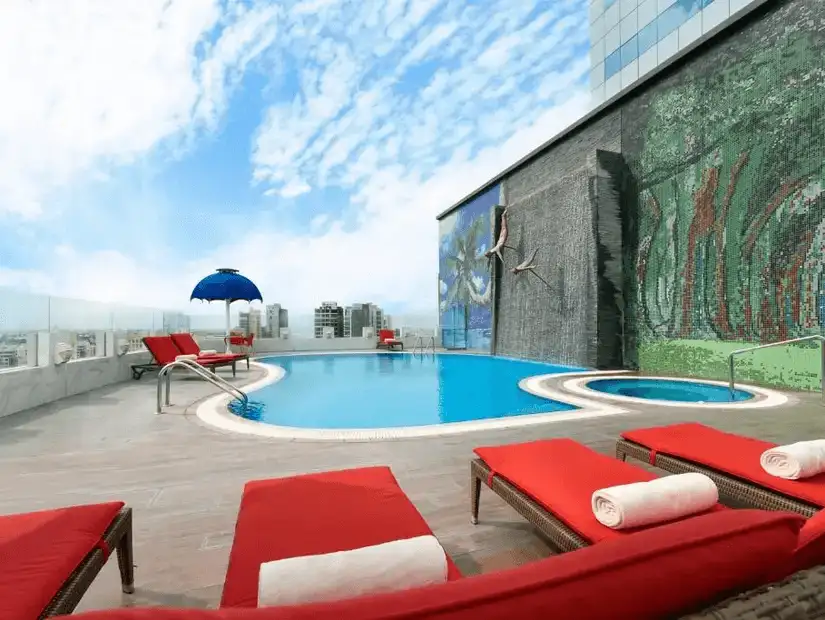 Hotel’s rooftop pool, complete with vibrant red loungers and stunning city views.