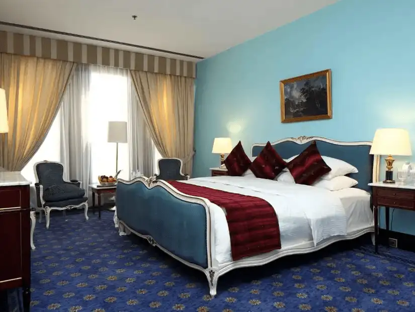 A stylish hotel room with twin beds and modern decor.