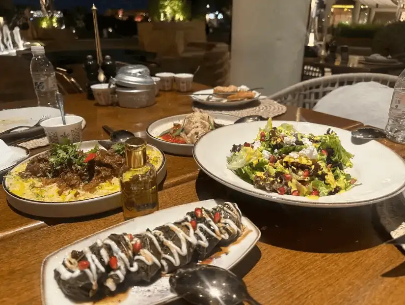 A traditional Arabic dish served with vegetables and some side salads.