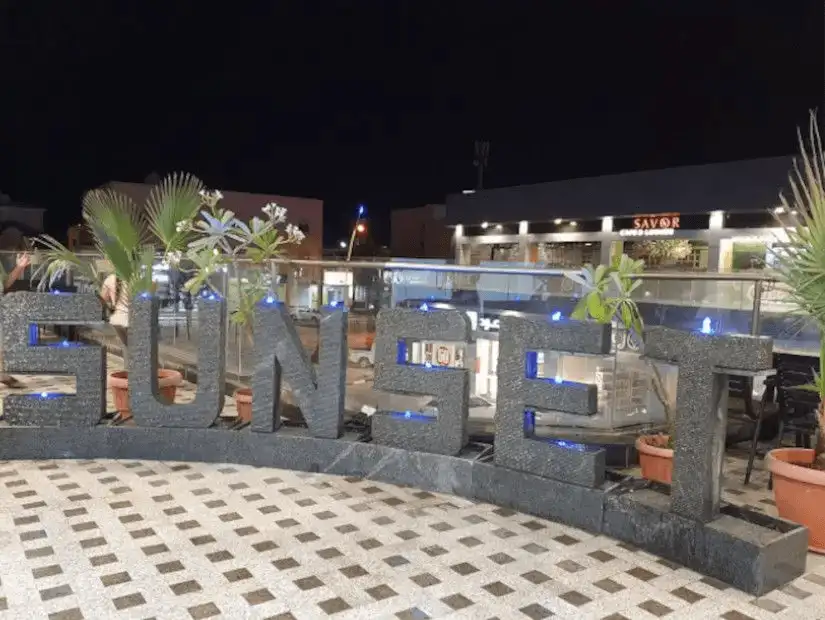 Sunset signage at The Grove Center, illuminated at night.