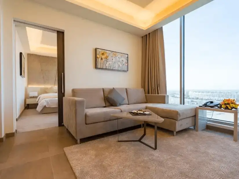 A spacious suite at The Grove Hotel & Conference Centre, featuring modern furnishings and floor-to-ceiling windows.